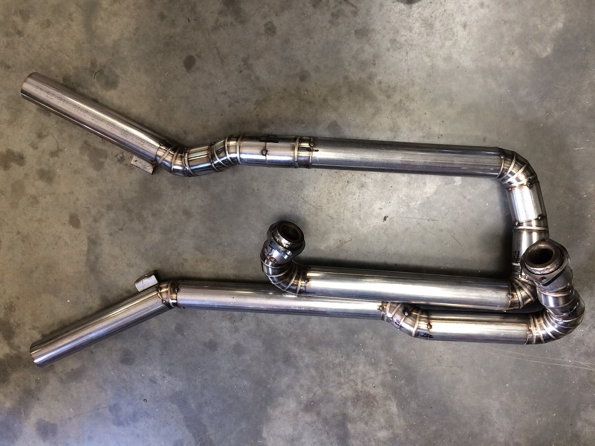 Welded stainless tube assemblies laid out on a shop floor, heat tint colouring the joints &mdash; representative imagery, not a specific Late Night Fabrication job